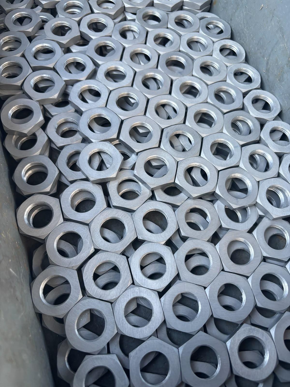 Tuercas hexagonales a granel — acabado mate uniforme en todo el lote.